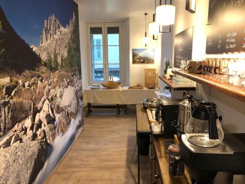 a room with a kitchen with a counter and a table at Hôtel du Nord in Corte