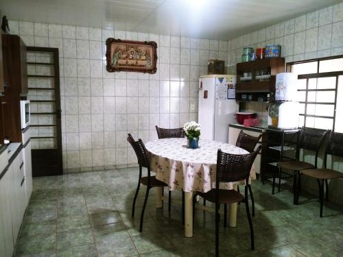 y cocina con mesa, sillas y nevera. en Aluguel para Temporada, en São Roque de Minas