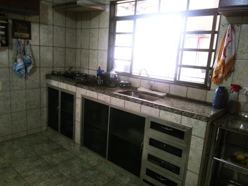 a kitchen with a sink and a counter top at Aluguel para Temporada in São Roque de Minas