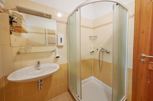 La salle de bains est pourvue d'un lavabo et d'une douche. dans l'établissement Rute Hotel and Apartments, à Kranjska Gora