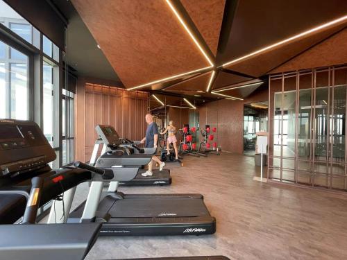 a gym with a row of treadmills and people on machines at EDGE Central Pattaya in Pattaya Central