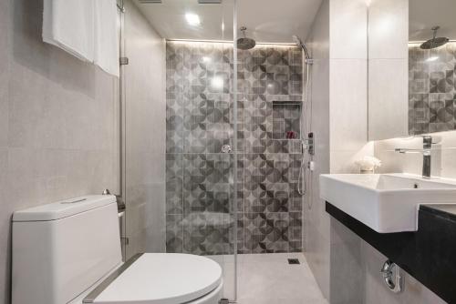 uma casa de banho com um WC, um lavatório e um chuveiro em Aspira Gems Center Silom em Banguecoque