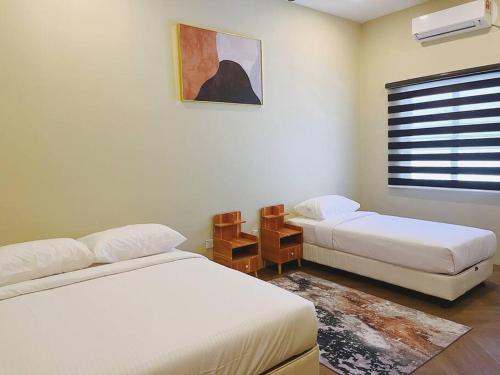 a small bedroom with two beds and a window at Villa D'Razna - Luxury 5-bedroom Villa with private pool in Kuala Terengganu