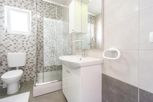 uma casa de banho branca com um WC e um lavatório em Reful Top modern facility with large terrace or balcony em Metajna