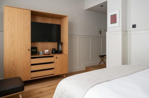 a bedroom with a large television in a wooden cabinet at RUNO Hotel Porvoo in Porvoo