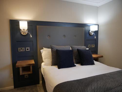a bedroom with a large bed with a blue headboard at Harbour House Inn Newcastle, Northern Ireland in Newcastle