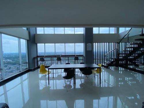 a dining room with a table and chairs in a building at Parkland Avenue Serpong BSD - Locca cafe in Babakan