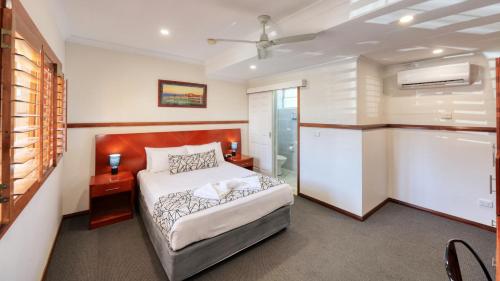 a bedroom with a bed and a bathroom with a tub at Across Country Motor Inn in Dubbo
