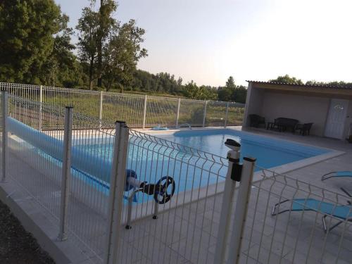 une piscine entourée d'une clôture dans l'établissement La Ferme des Augustines, à Belluire