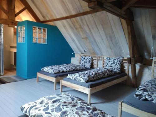 Zimmer mit 3 Betten und blauer Wand in der Unterkunft La Ferme des Augustines in Belluire