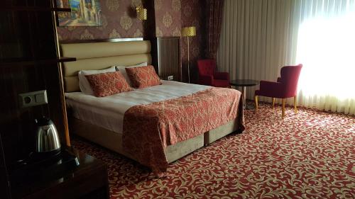 a hotel room with a bed and a table at Savona Otel Sivas in Sivas