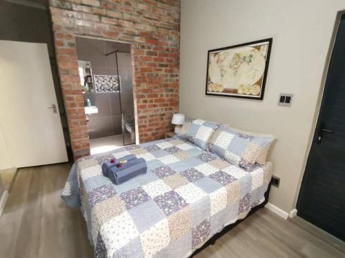 1 dormitorio con cama y pared de ladrillo en Platform 162 en Ciudad del Cabo