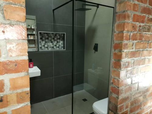 uma casa de banho com uma cabina de duche em vidro e um WC. em Platform 162 na Cidade do Cabo