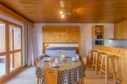 une salle à manger avec une table et une cuisine dans l'établissement Les Dryades - Appartement lumineux avec grand balcon et vue sur la montagne, à Les Allues
