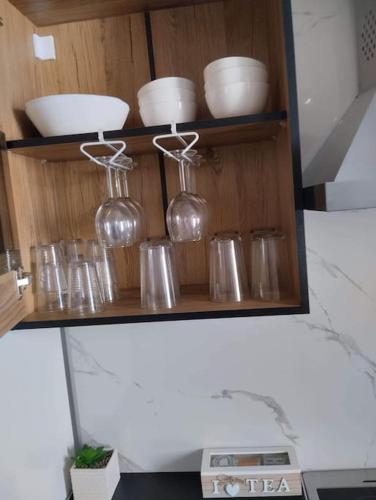 a wooden shelf with glasses and bowls on it at AcroLofts M62 in Athens
