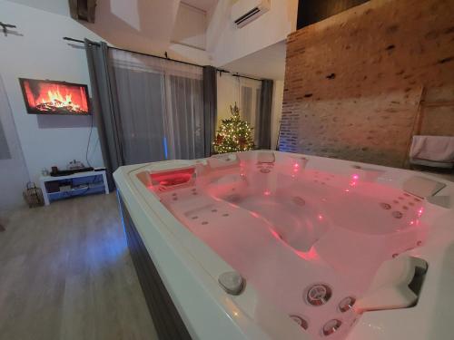 een bad in een kamer met een kerstboom bij Eaudyssée maison avec SPA privée - Loiret in Ladon