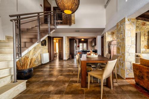 ネア・スキオニにあるPalmrise Luxury Villas by Travel Pro Services - Nea Skioni Halkidikiのダイニングルーム(テーブル、椅子、階段付)