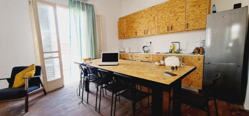 een keuken met een tafel en een laptop bij Bee Hostel Paphos in Paphos City