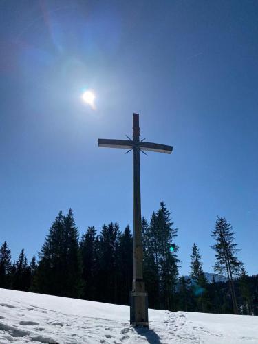 a cross on top of a snow covered field at Hotel Casa Maria in Halblech