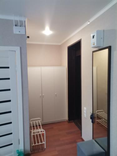 a room with white cabinets and a mirror at Однокомнатная квартира-студия в Гагре! Море солнца in Gagra