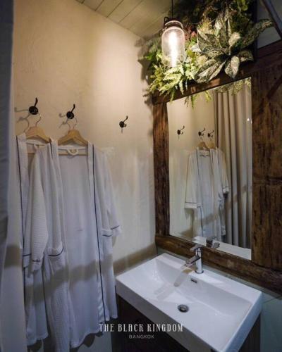 a bathroom with a sink and a mirror at The Black Kingdom - เดอะ แบล็ค คิงดอม in Bangkok