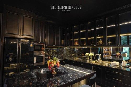 バンコクにあるThe Black Kingdom - เดอะ แบล็ค คิงดอมのキッチン(黒いキャビネット、花崗岩のカウンタートップ付)