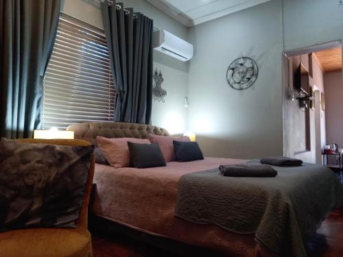 a bedroom with a bed and a clock on the wall at Mountainia Inn in Worcester