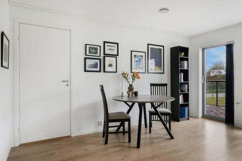 a dining room with a table and chairs at Moderne leilighet - nært flyplass - lader for elbil in Råholt
