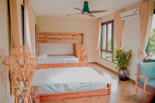 a bedroom with two bunk beds and a chair at The Bright House Villa - Venuestay in Hanoi