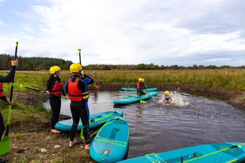 a group of people on a river with kayaks at Wildlands Galway in Moycullen