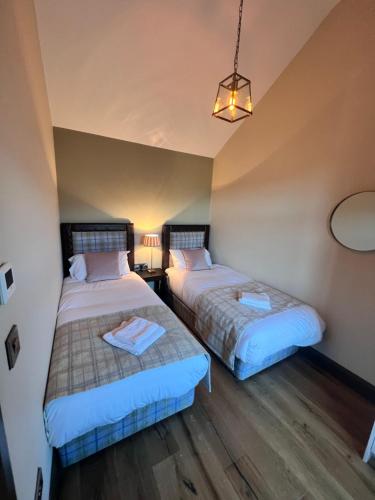 a room with two beds and a lamp at Wildlands Galway in Moycullen