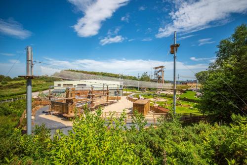 a park with wooden benches and a playground at Wildlands Galway in Moycullen