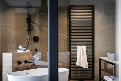 a bathroom with a white tub and a sink at Aparthotel My Daum in Nova Ponente