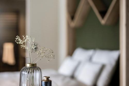a glass vase with flowers in it on a table at Aparthotel My Daum in Nova Ponente