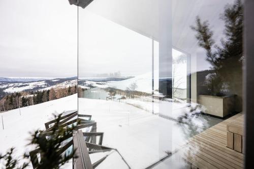 a glass house with a view of the snow at Aparthotel My Daum in Nova Ponente