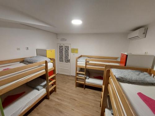 a dorm room with three bunk beds in it at Hostel Inn Downtown in Belgrade