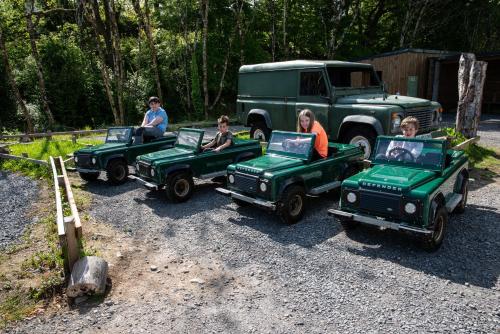 a group of people riding in small green jeep cars at Wildlands Galway in Moycullen