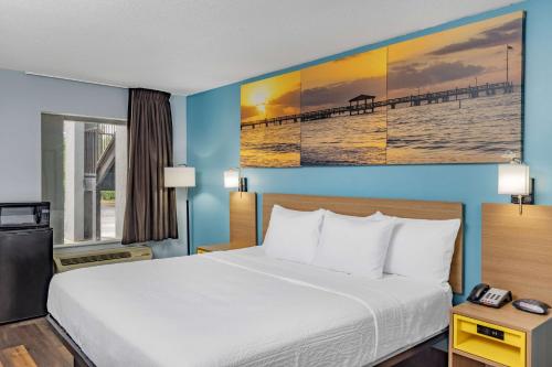 a hotel room with a bed and a view of a pier at Days Inn by Wyndham Pensacola I-10 in Pensacola