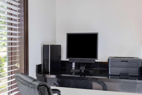 a living room with a tv and a chair at Days Inn by Wyndham Pensacola I-10 in Pensacola