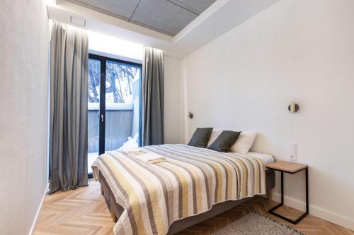 ein Schlafzimmer mit einem Bett mit einer gestreiften Decke in der Unterkunft Renaissance Key Apartment 29 in Vilnius