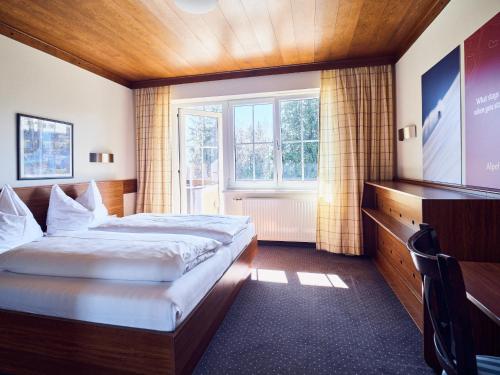 ツェル・アム・ゼーにあるHotel Pinzgauerhof by Alpeffect Hotelsのベッドとテレビが備わるホテルルームです。