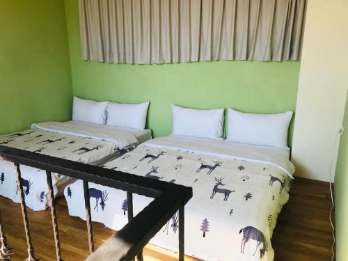 two beds in a room with green walls at Taroko Mountain View B&B in Shunan