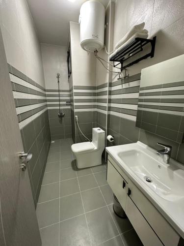 a bathroom with a toilet and a sink at Blue Rose Hotel in Al Amarat