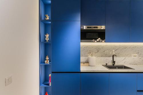 eine blaue Küche mit einer Spüle und einer Theke in der Unterkunft Blue Moon Apartments in Braşov