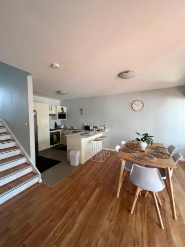 a living room with a table and a kitchen at Furnished Home near Newcastle and Warners Bay in Mount Hutton