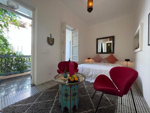 una camera con letto, tavolo e sedie di Riad Albatoul a Marrakech