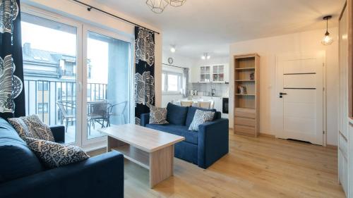 a living room with a blue couch and a table at Spokojna, Sun & Snow in Wisła