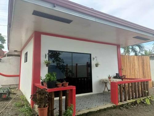 a house with a red and white facade at Portofino Homestay in Malitbog