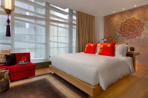 فندق انديجو هونغ كونغ آيلاند في هونغ كونغ: غرفة نوم مع سرير أبيض كبير مع وسائد حمراء
