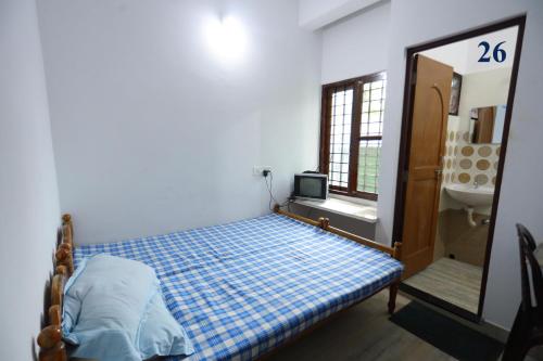 a bedroom with a bed and a sink and a mirror at Arackal Tourist Home in Tripunnittara